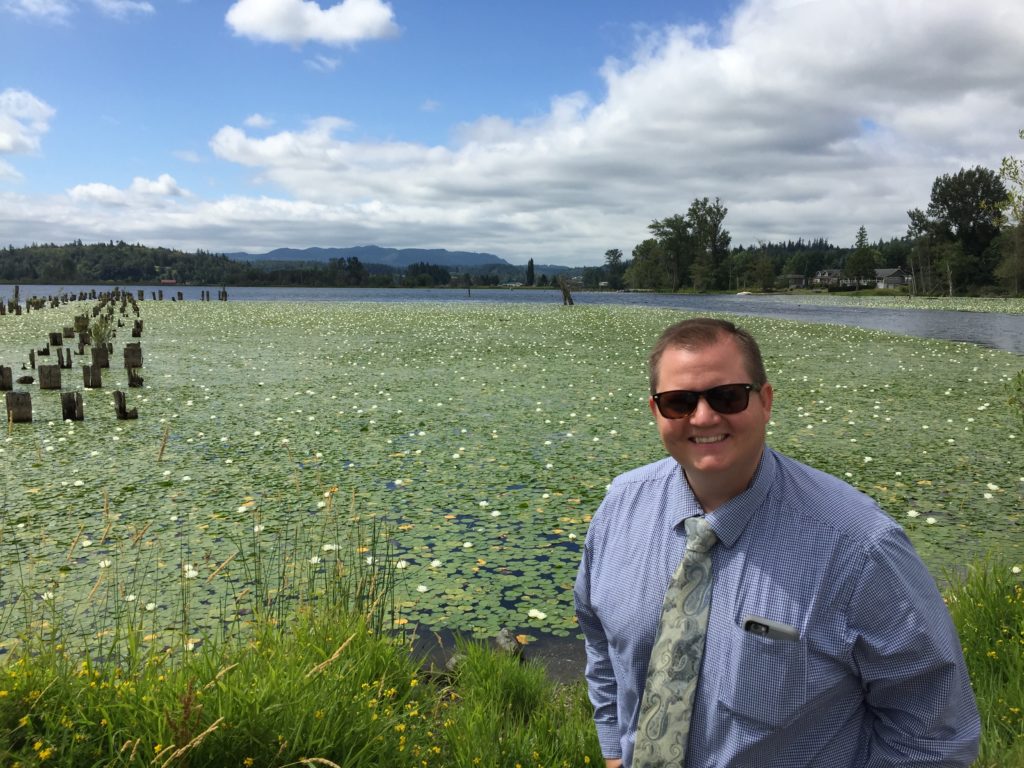 Jordan Disch standing in front of a lake full of waterlilies